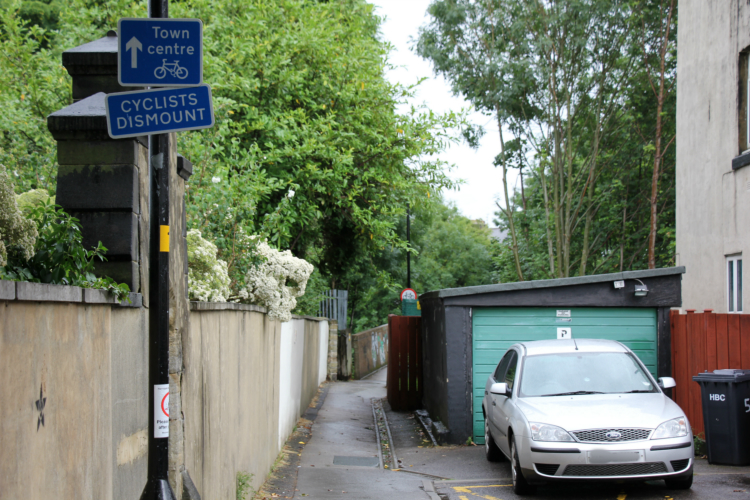 Cyclists dismount sign before railway bridge